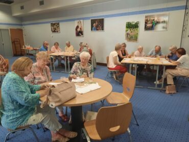 Habitants réunis autour de tables-rondes.