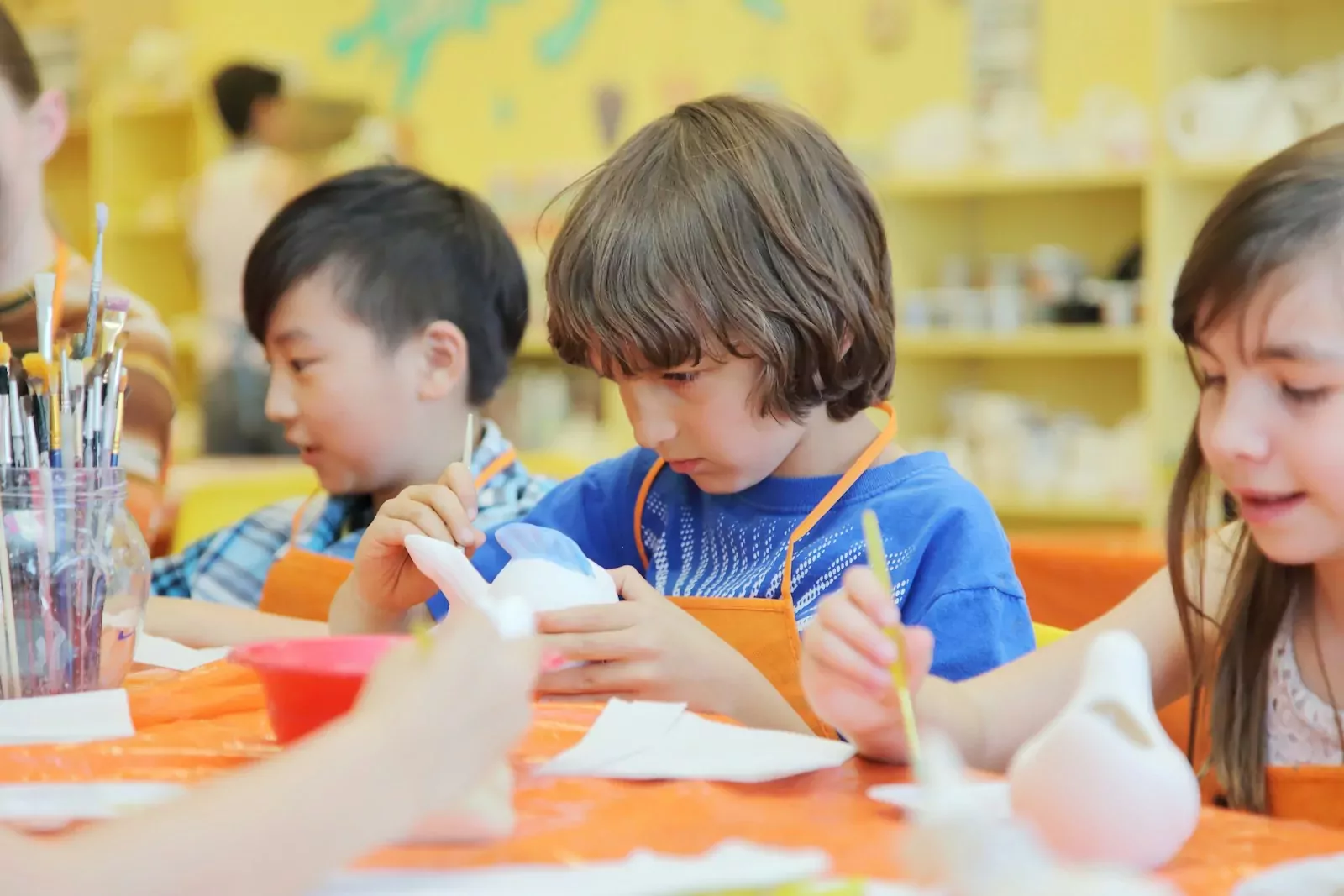 Children painting ceramic figures in an art class